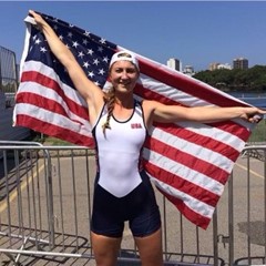 Dani, a rowing athlete, standing with an American flag draped behind her as she holds it at the corners with her hands.