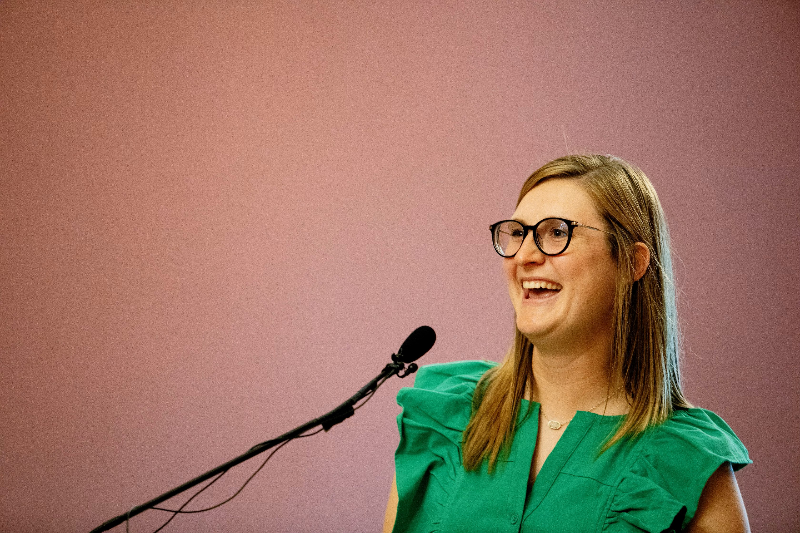 a smiling Ashley leading a press conference