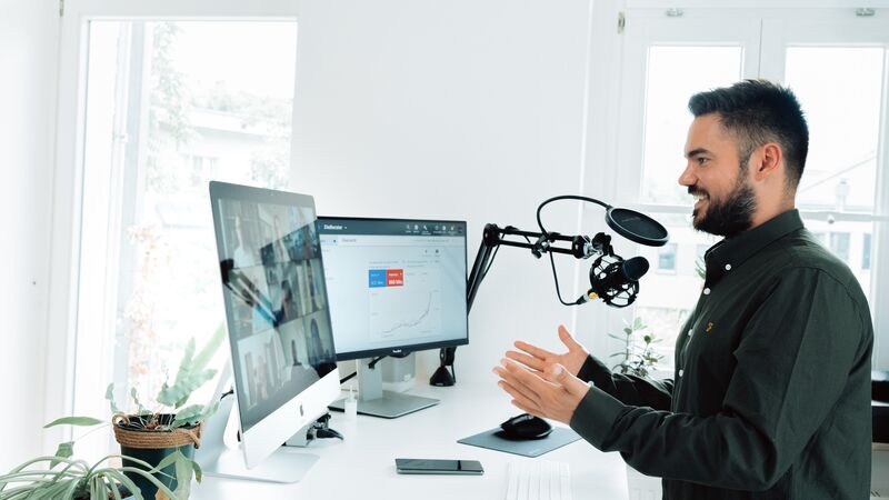 Man in a video call with two screens in a webinar like environment.