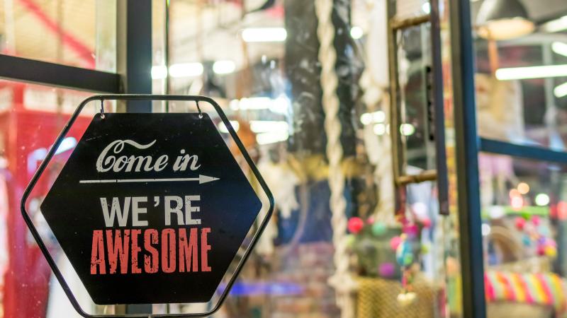 A sign in front of a business reads Come in We’re Awesome