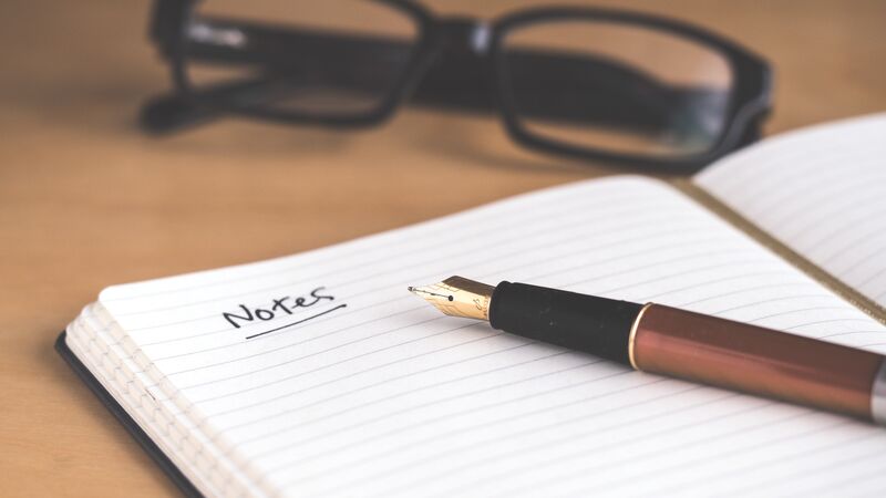 Open notebook with a pen and glasses.