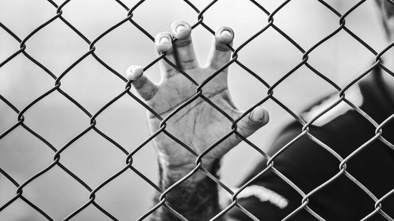 Hand on Chain Link Fence