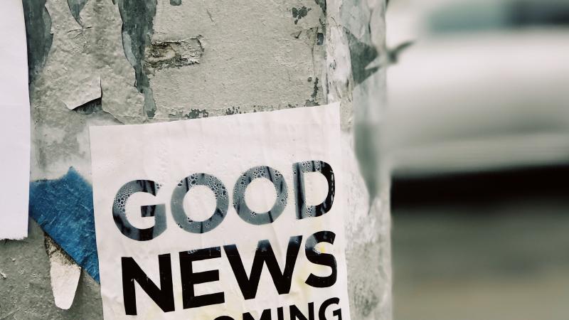 A sign on a street pole that reads, “good news is coming.”