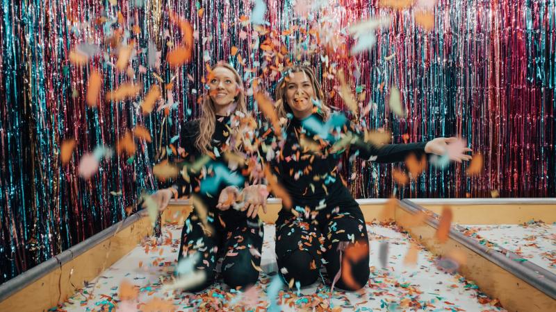 two people celebrating with confetti and streamers