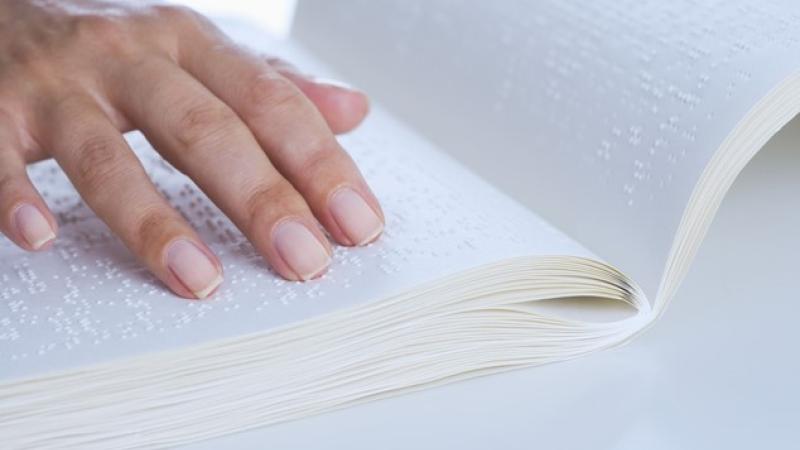 Hand upon braille book
