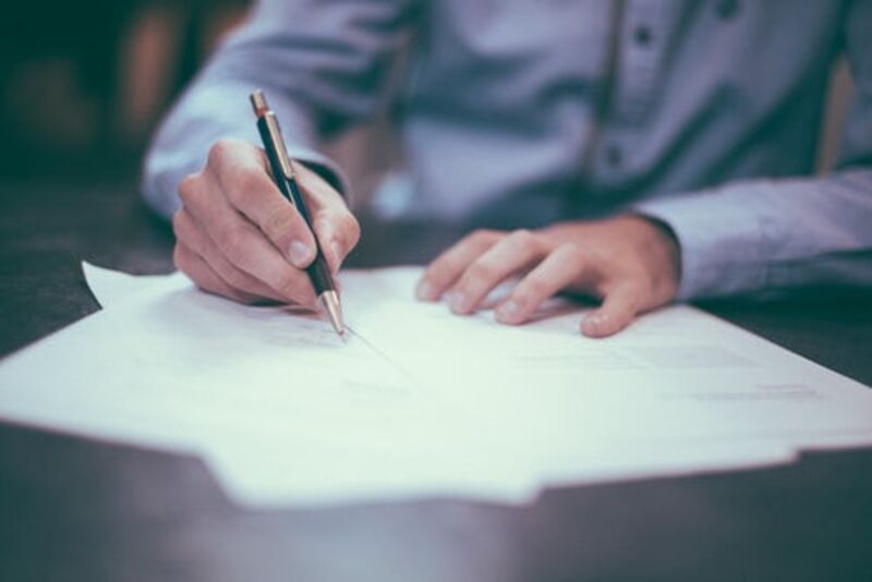 man writing on paper.jpg Thumbnail