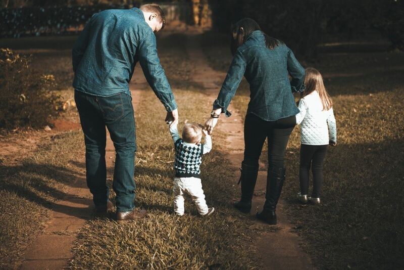 Father and Mother walking with toddler son and young daughter.
