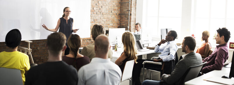 Instructor leading a discussion topic in front of a group of people.