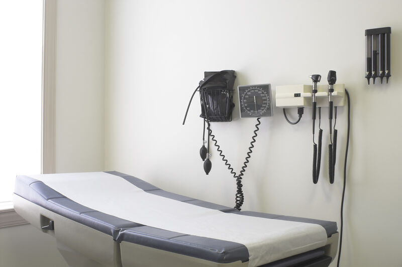 An exam table against a wall in a doctor's office.