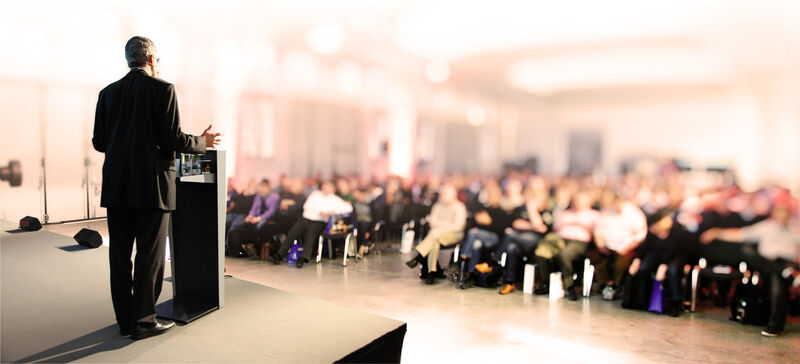 A moai behind a podium giving a speech