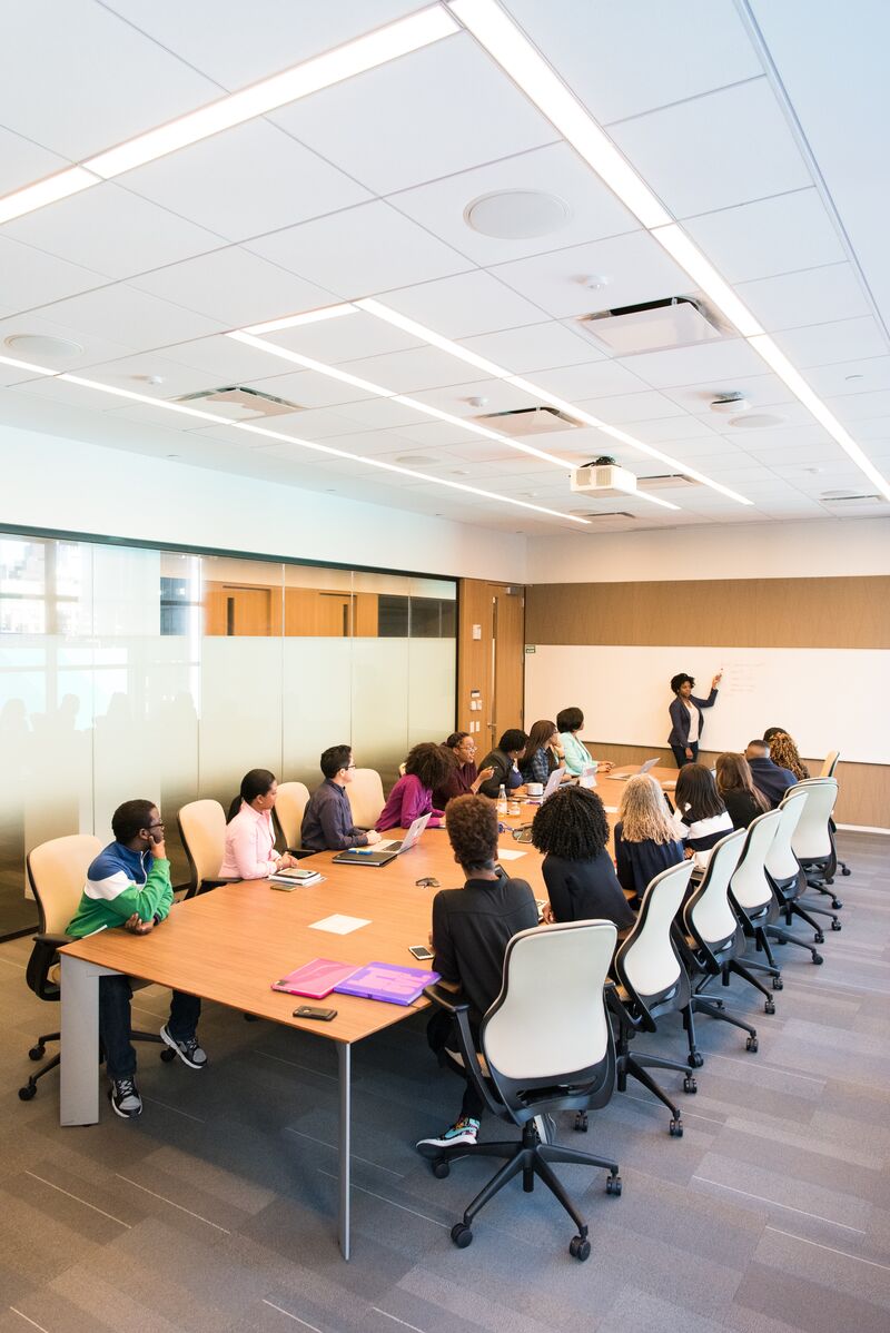 People in meeting with a speaker in front of a whiteboard