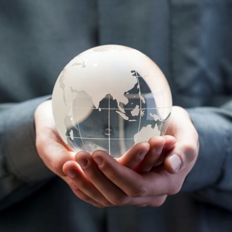 Person holding a glass globe in hands.