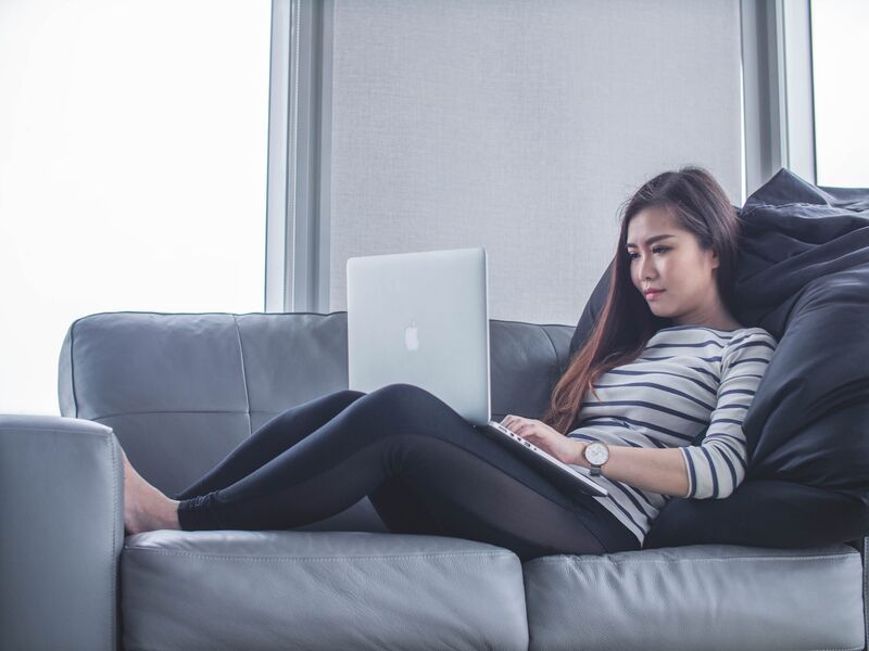Woman on a couch working on a laptop