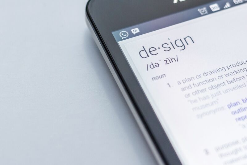 Close-up shot of a smartphone with a definition of the word design. 