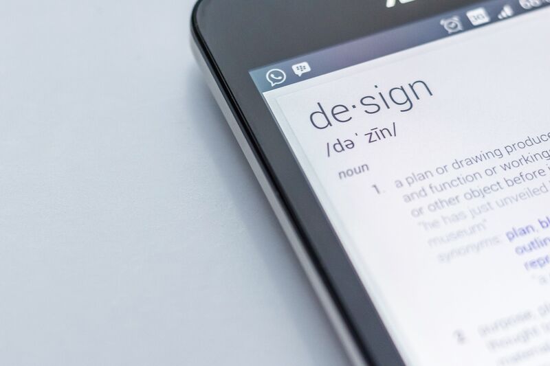 Close-up shot of a smartphone with a definition of the word design.