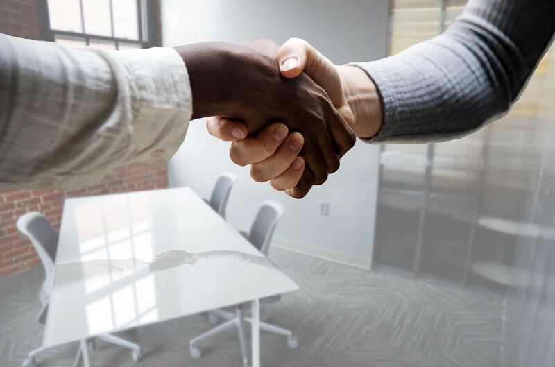 a black person's hand and a white person's hand in a handshake