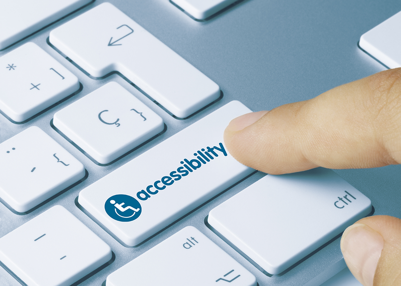 a close up of someone pressing a button on a keyboard with an accessibility wheelchair icon