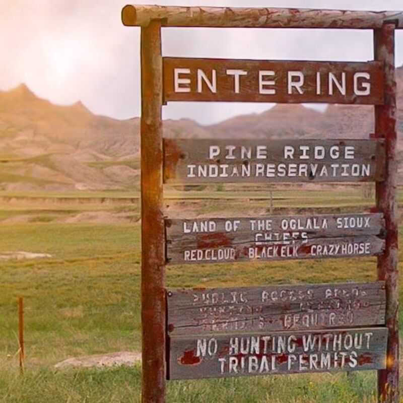 wooden sign that reads Entering Pine Ridge Indian Reservation