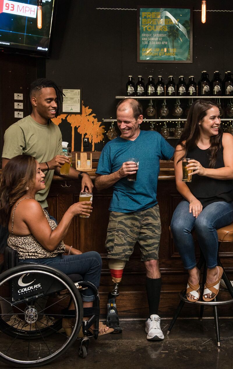 a group of people gathered at a bar smiling and drinking