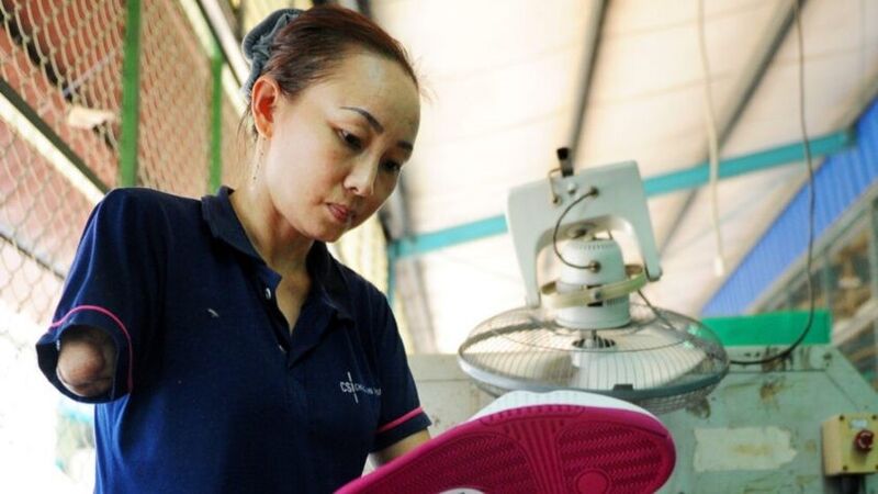 a brown haired woman and no arm below her elbow is working on a shoe