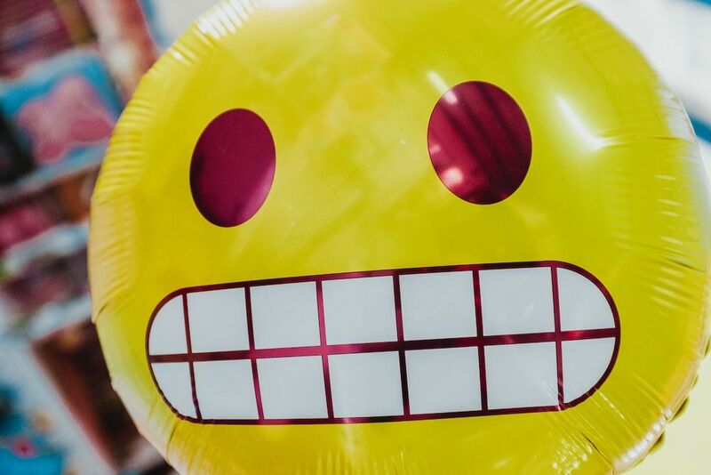 a yellow balloon with an awkward smiley face