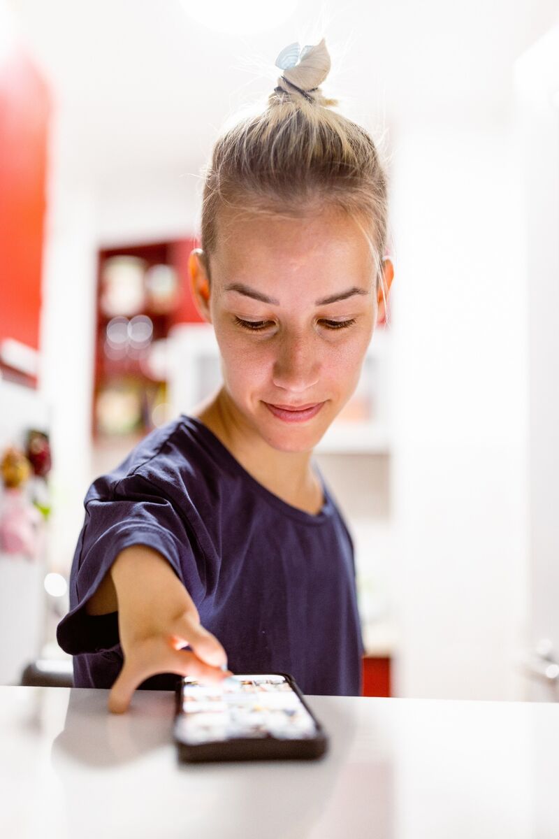 Woman with a right-arm reduction and three fingers scrolling through a mobile phone