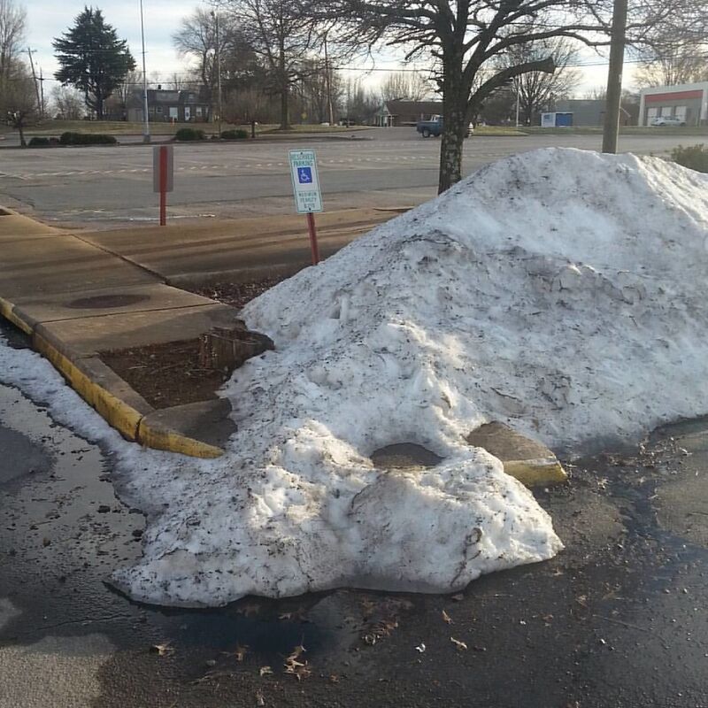 a pile of snow that's left on a handicapped parking spot