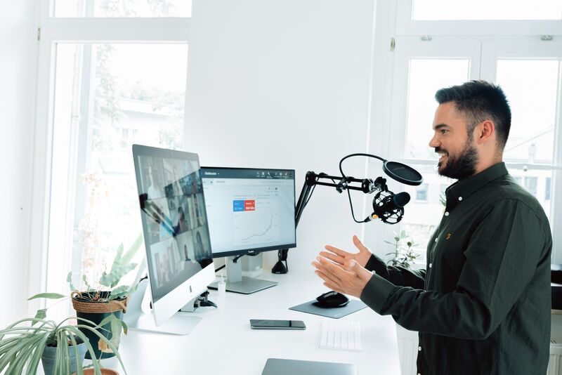 Man in a video call with two screens in a webinar like environment.