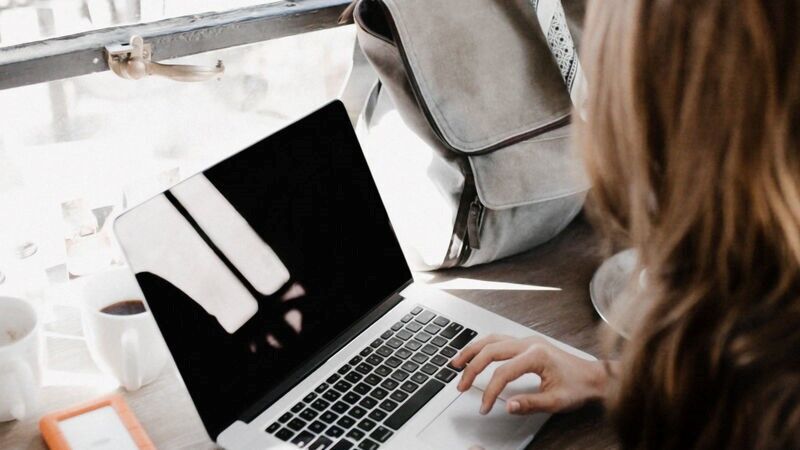 a young woman looking at her laptop in a coffee shop