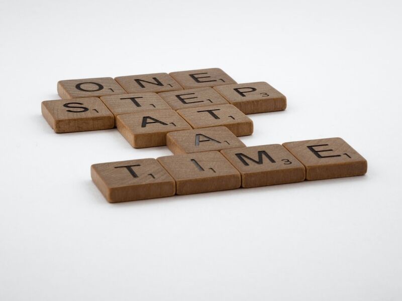 wooden blocks that says "one step at a time"