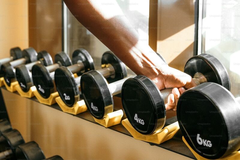 a hand reaching out for a dumbbell 
