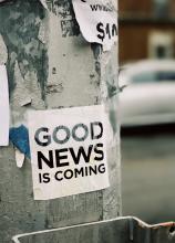 A sign on a street pole that reads, “good news is coming.”