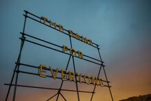 a large outdoor light-up sign which reads "The Same for Everyone" with the sky at dusk in the background