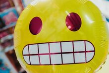 a yellow balloon with an awkward smiley face