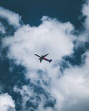 Airplane in the sky against a background of clouds. Photo by Erik Gazi on Unsplash