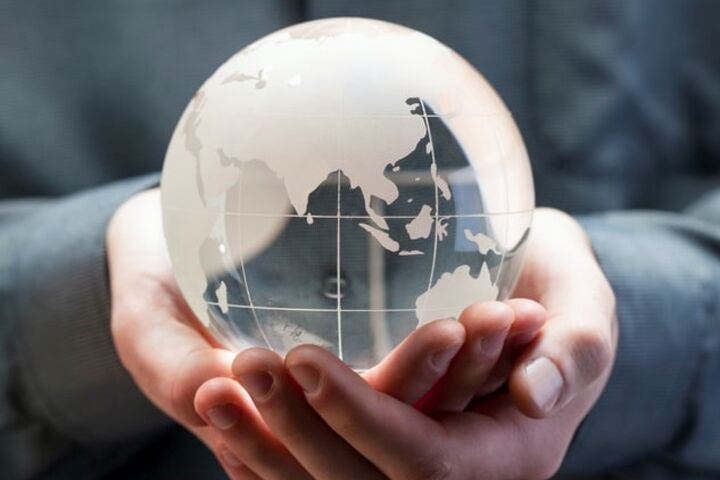 Person holding a glass globe in hands.