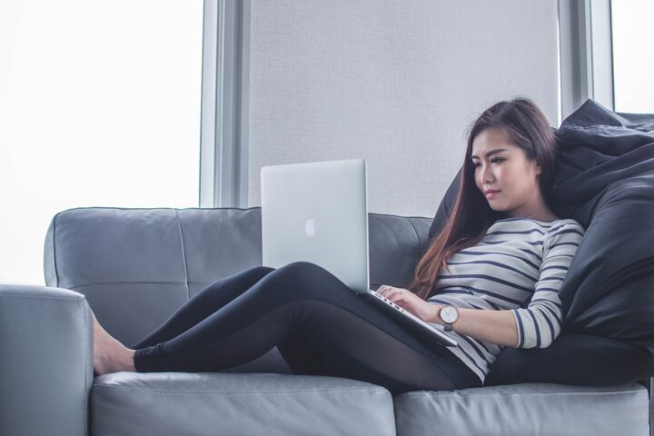 Woman on a couch working on a laptop