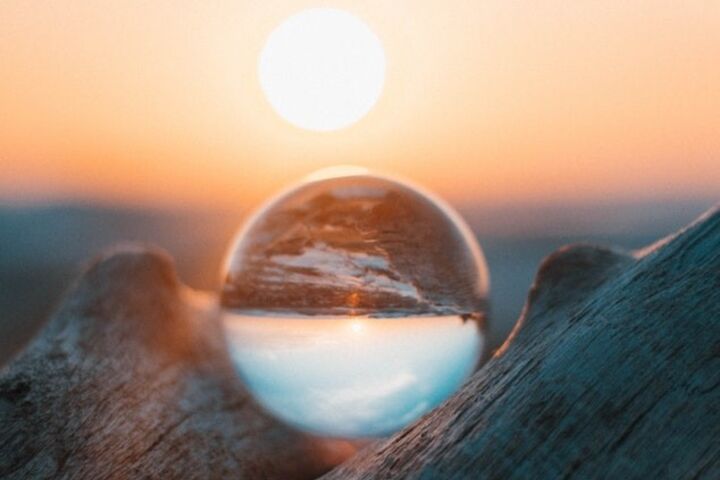 Sun rising behind a glass crystal ball.