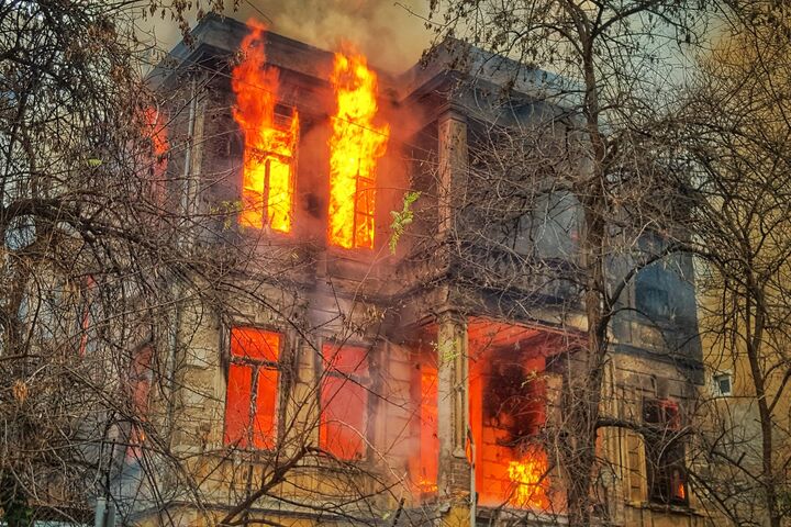 A burning building with flames coming out of the windows