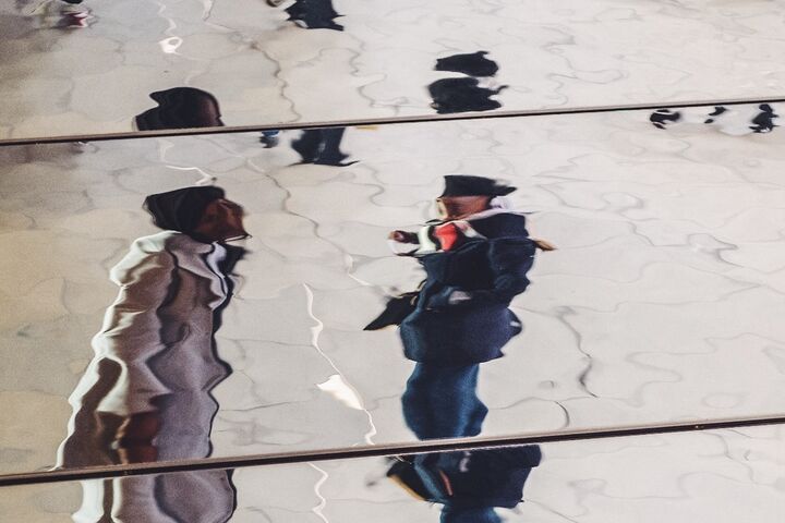 two people in a watery reflection