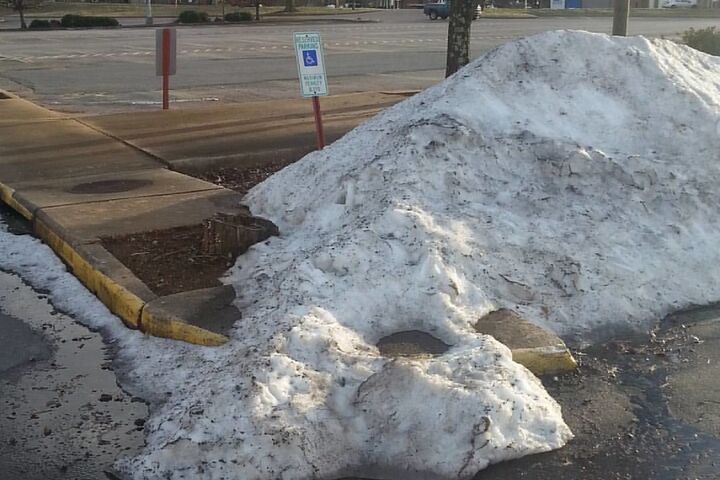 a pile of snow that's left on a handicapped parking spot