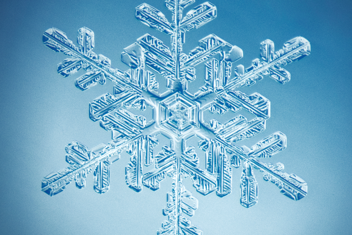 a close up of a snowflake on a blue background