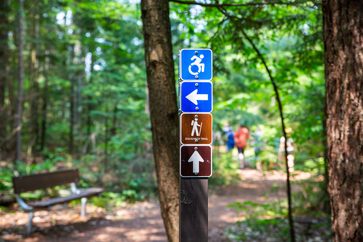 a wheelchair accessible sign on a walking trail in the woods