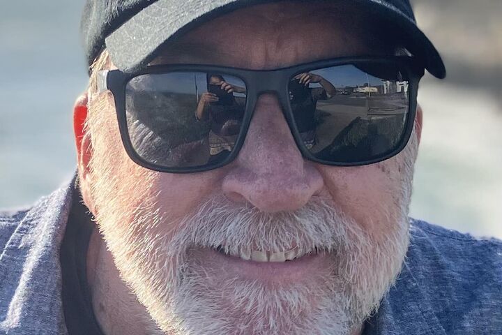 Foster Andersen wears a smile and his branded Shared Adventures baseball cap.