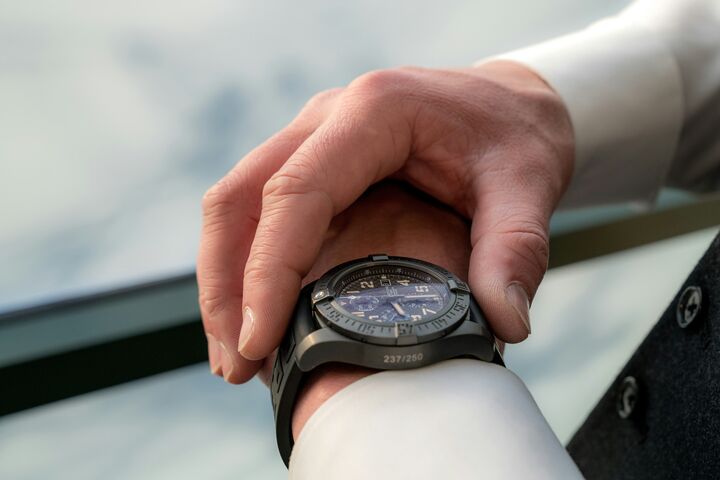 a man's hand is zoomed on, holding on to his black watch