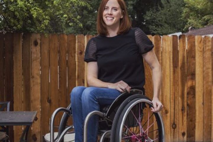 Katherine Beattie sits in her wheelchair and smiles.