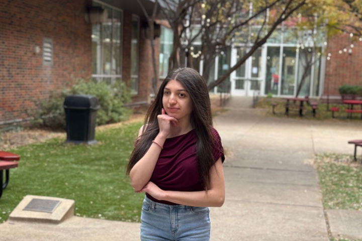 Delila Vasquez stands with an arm crossed, the other at a fist that rests on her chin.