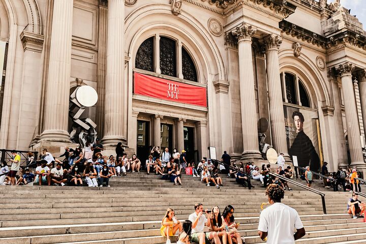 people sitting on the stairs outside the Metropolitan Museum of Art's entrance