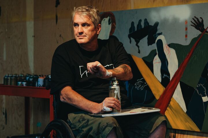 Murray Siple in his wheelchair uses spray paint to create art.