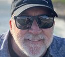 Foster Andersen wears a smile and his branded Shared Adventures baseball cap.